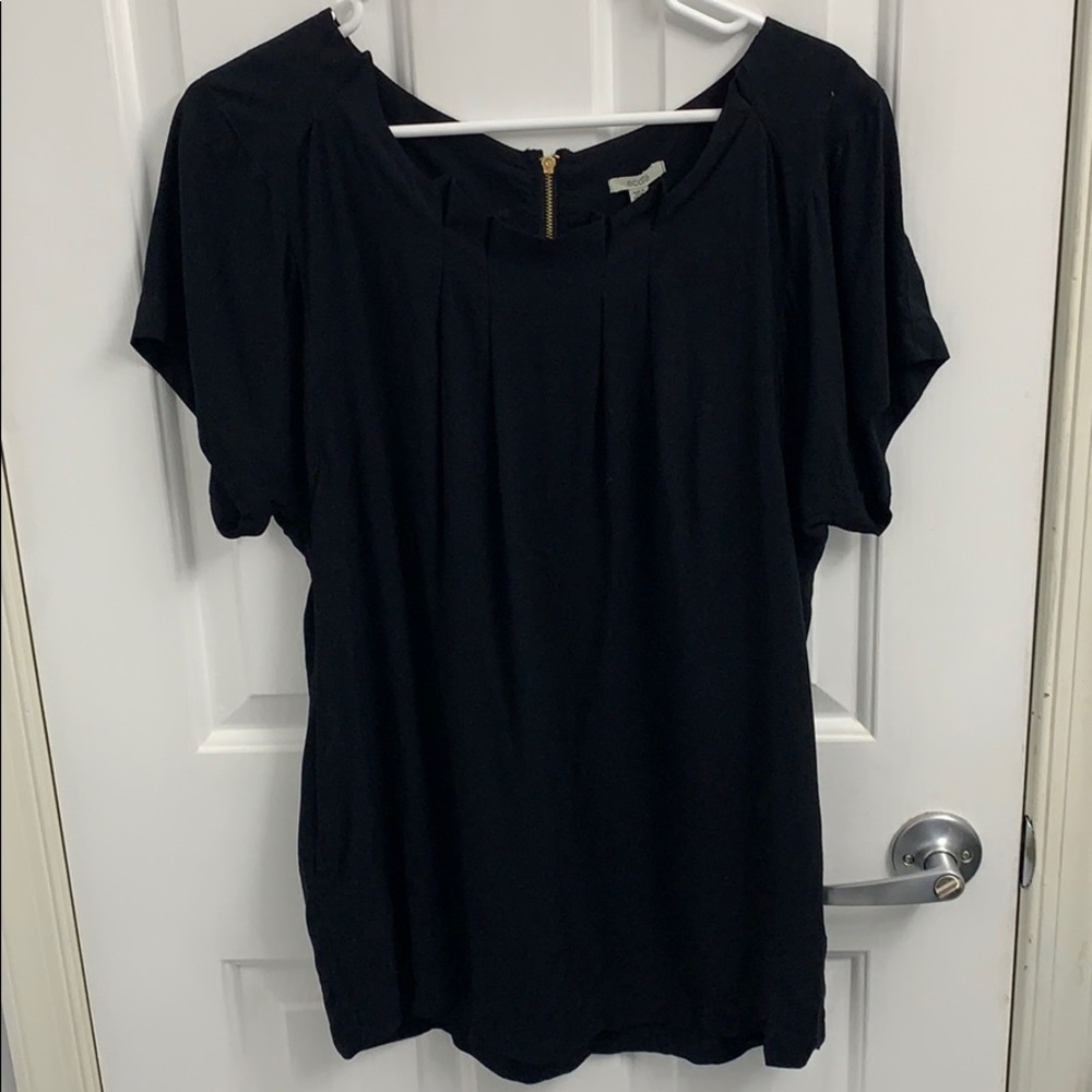 Black short sleeve top with a gold zipper in back